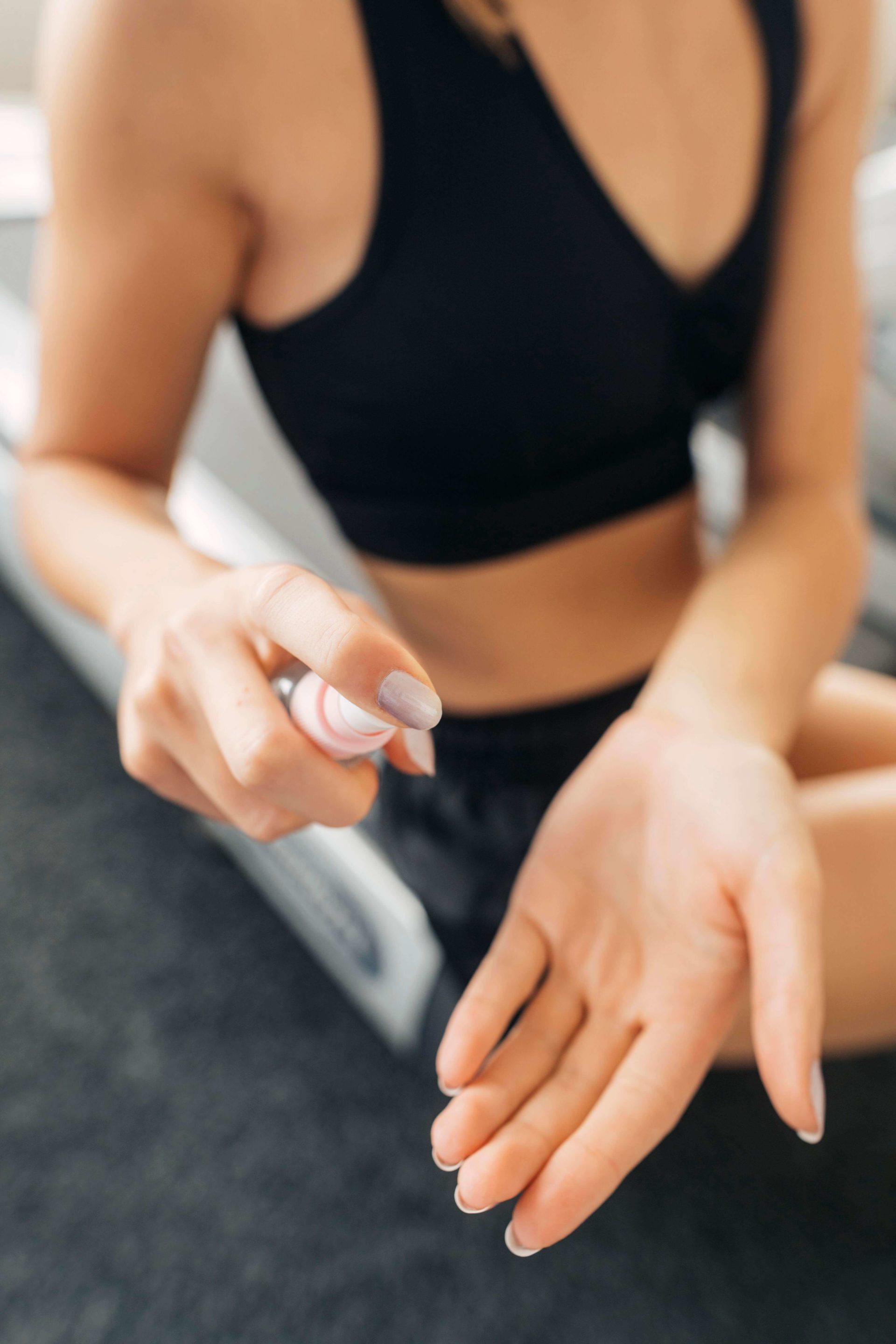 Une femme utilise une huile de massage au CBD après une séance sportive, prenant soin de ses muscles et articulations. Ce geste associe bien-être, relaxation et ingrédients naturels premium.